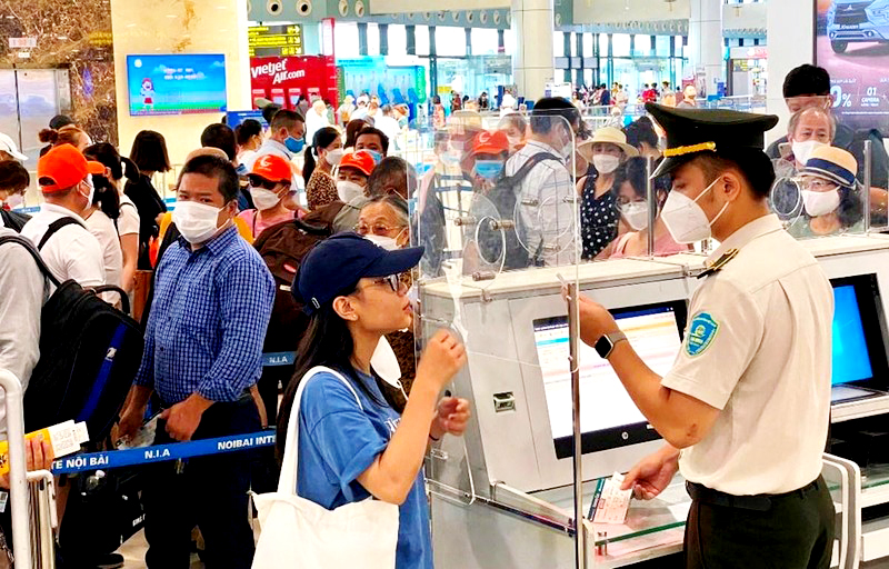  Nhân viên an ninh hàng không kiểm tra hành khách làm thủ tục bay. (Ảnh: CTV/Vietnam+)