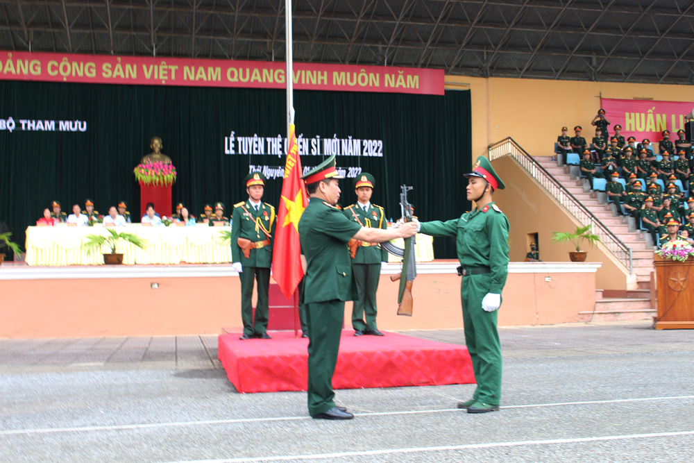  Thiếu tướng Hà Quang Vinh, Phó Tham mưu trưởng Quân khu 1, thực hiện nghi thức trao súng cho chiến sĩ mới.