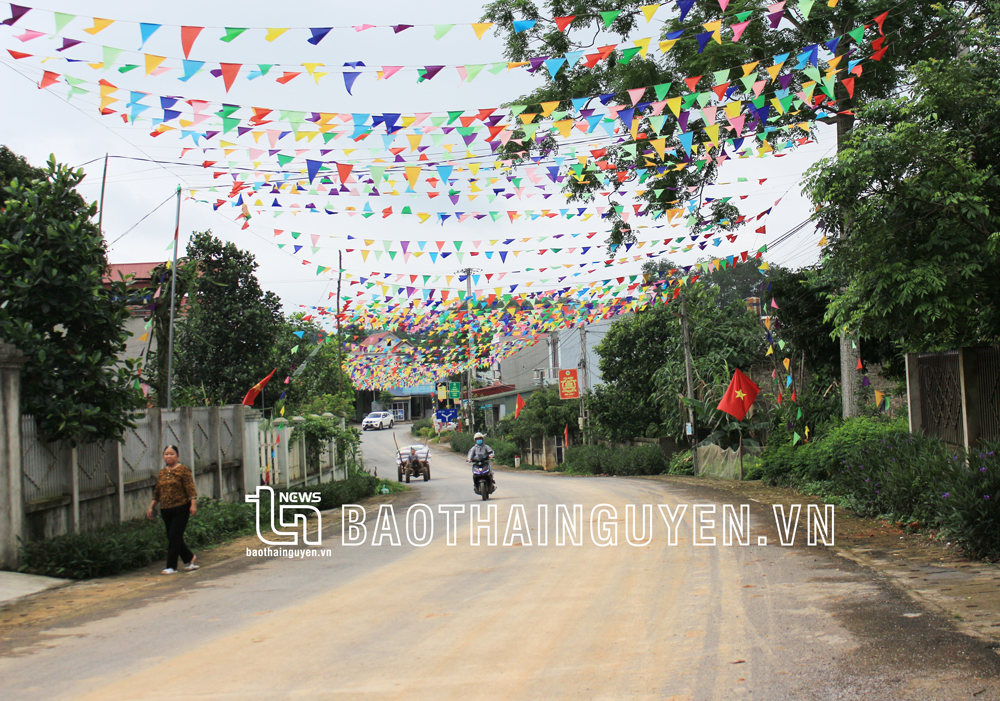  Người dân địa phương treo cờ trang trí tại một số đoạn đường để mừng tuyến đường mới hoàn thành.