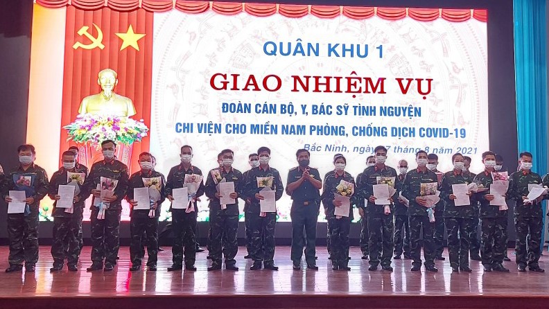  Thiếu tướng Trần Văn Kình, Phó tư lệnh Quân khu trao quyết định điều động tạm thời và tặng hoa động viên các y, bác sĩ tăng cường vào Nam chống dịch.