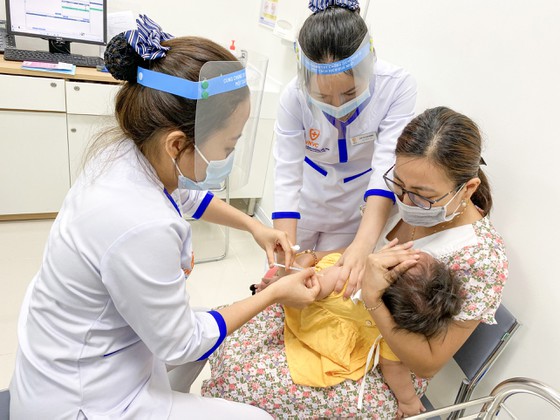  Phụ huynh đưa trẻ đi tiêm vaccine nhắc lại để phòng bệnh.