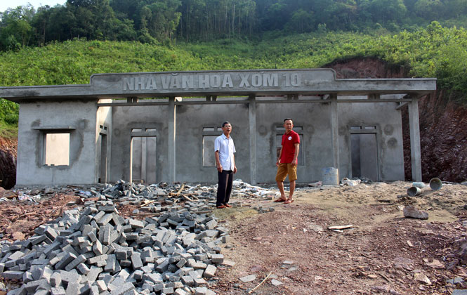  Ông Trần Quang Tung, Bí thư Chi bộ xóm 10 (ngoài cùng bên trái) bên công trình nhà văn hóa xóm 10 mà gia đình ông đã hiến gần 1.000m2 đất để xây dựng.