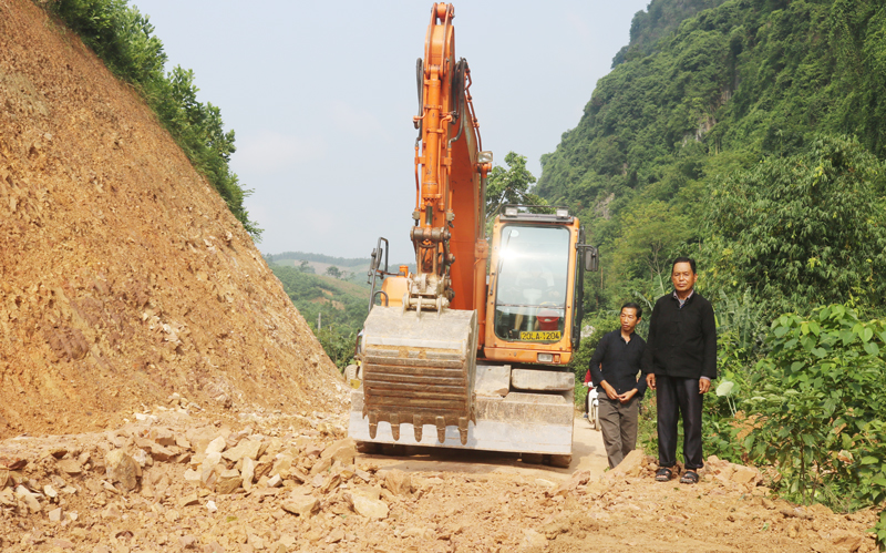  Ông Lầu Văn Vừ (bên phải) tham gia giám sát đơn vị thi công mở đường trục của xóm.