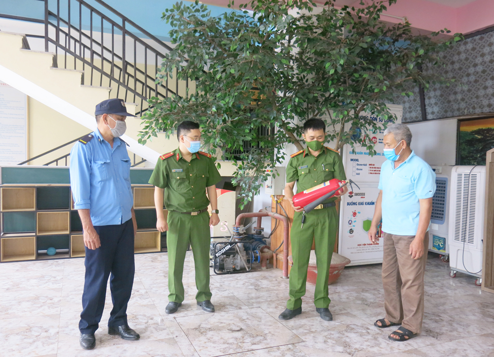  Công an phường Đồng Bẩm (TP. Thái Nguyên) hướng dẫn cách sử dụng bình chữa cháy cho các thành viên tổ PCCC của Trường Mầm non – Tiểu học DPA. Ảnh: T.L