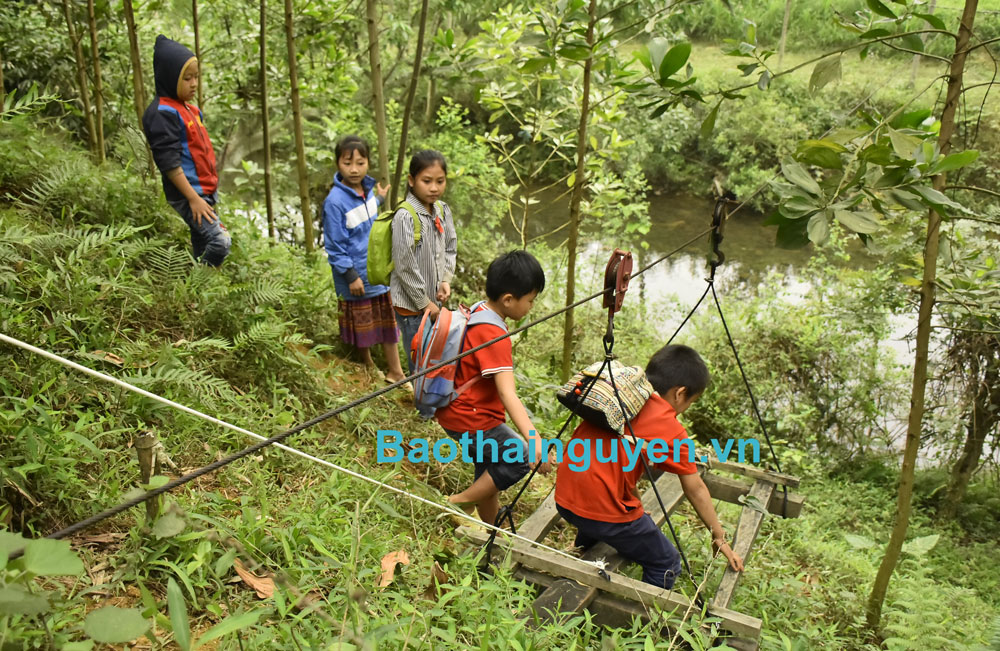  Mùa mưa lũ, các em học sinh phải đu dây cáp treo qua suối mới đến được lớp học.