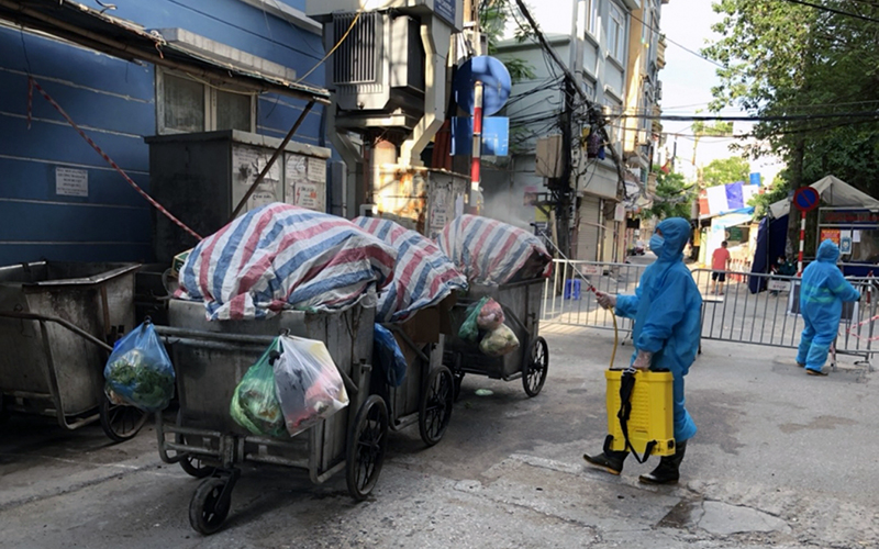  Rác thải tại khu vực cách ly y tế ở quận Ðống Ða được công nhân Công ty TNHH Môi trường đô thị Hà Nội quây bạt che kín và phun khử khuẩn trước khi vận chuyển đi xử lý.