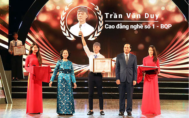  Các đồng chí: Trương Thị Mai, Ủy viên Bộ Chính trị, Bí thư Trung ương Đảng, Trưởng Ban Dân vận Trung ương; Đào Ngọc Dung, Bộ trưởng Bộ Lao động, Thương binh và Xã hội trao thưởng cho sinh viên Trần Văn Duy, Trường Cao đẳng nghề số 1, Bộ Quốc phòng.